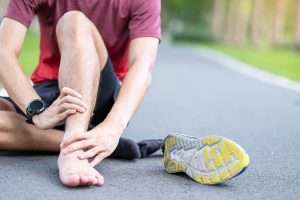 A person struggling with symptoms of Achilles Tendonitis