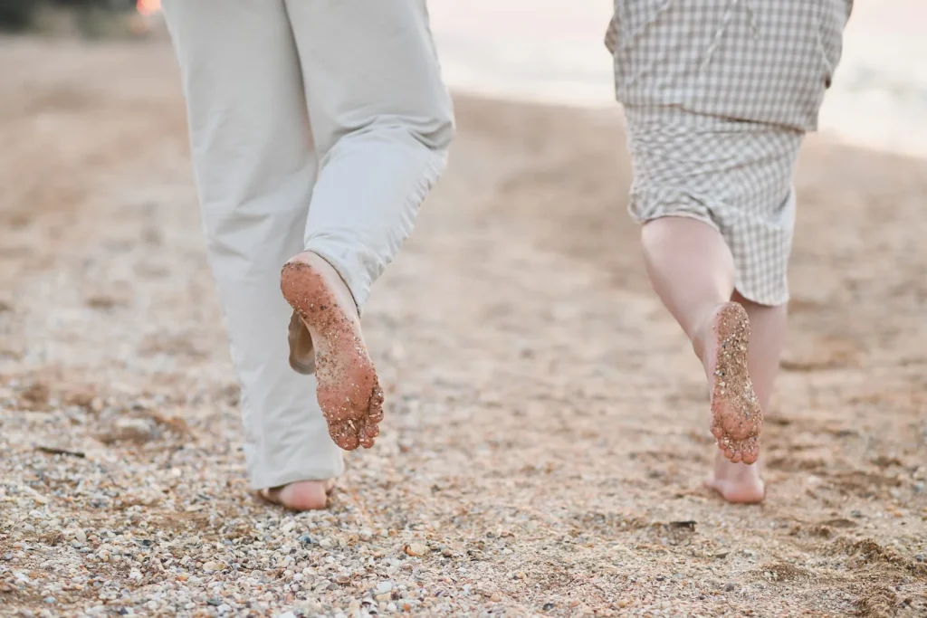 happy couple running on the beach barefoot